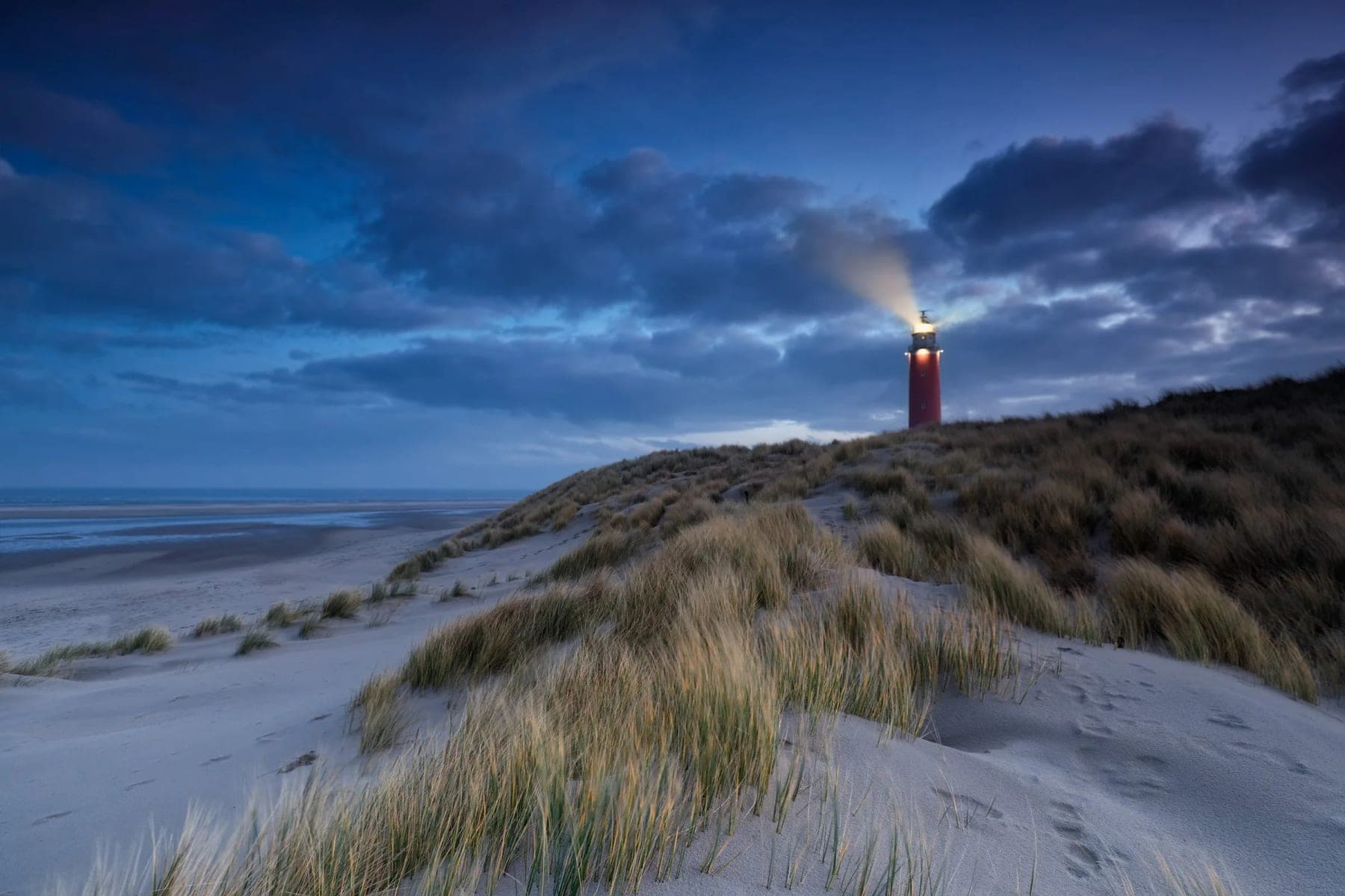 Vuurtoren op een duin in de schemering